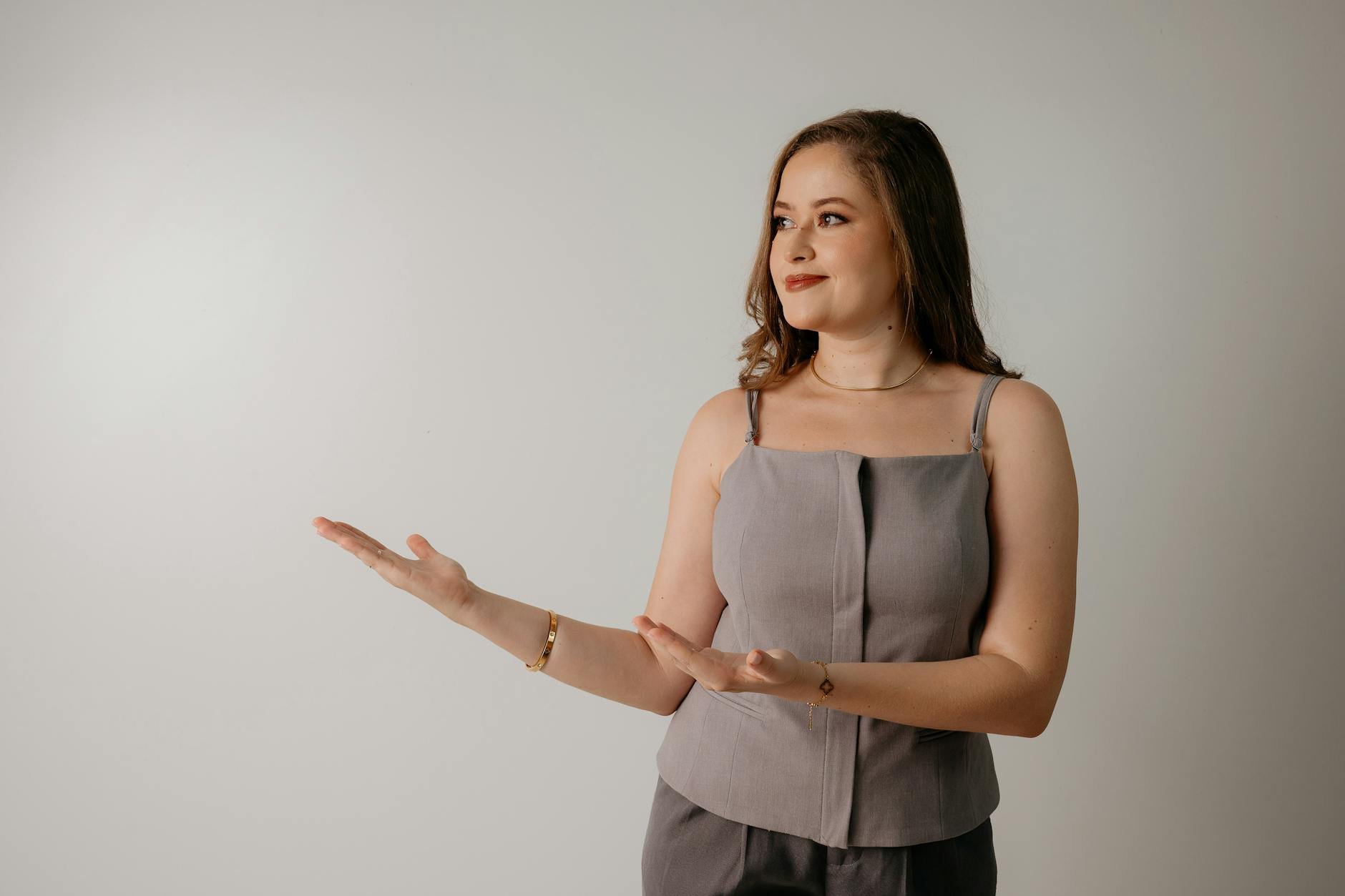 Mulher de cinza gesticulando em fundo branco, ilustrando página de vendas eficaz