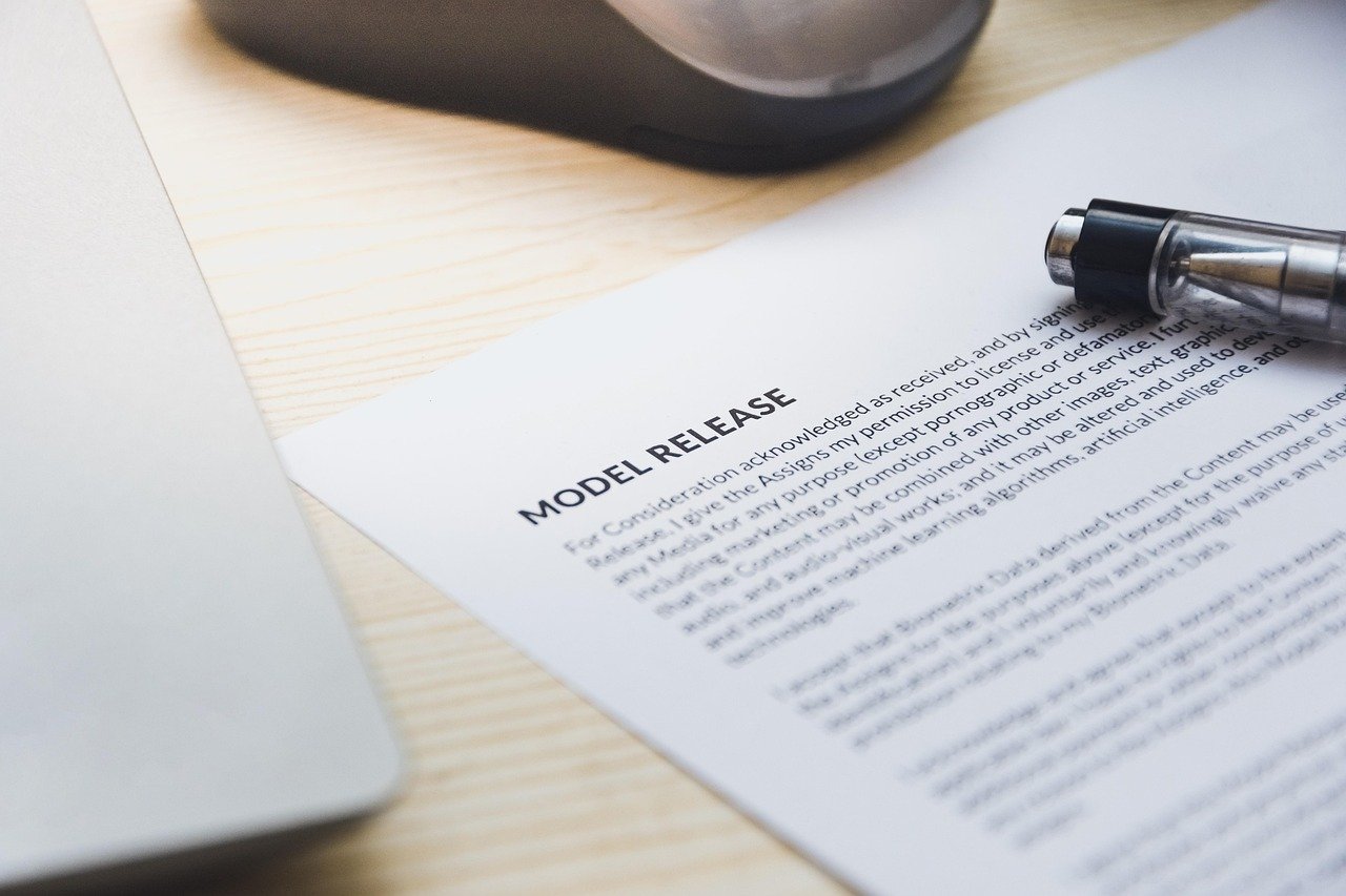 Documento e caneta em escrivaninha ilustrando aspectos legais na coleta de e-mails com anúncios