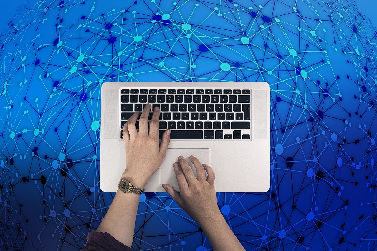 Mãos digitando em teclado para captar e-mails com anúncios de forma eficiente