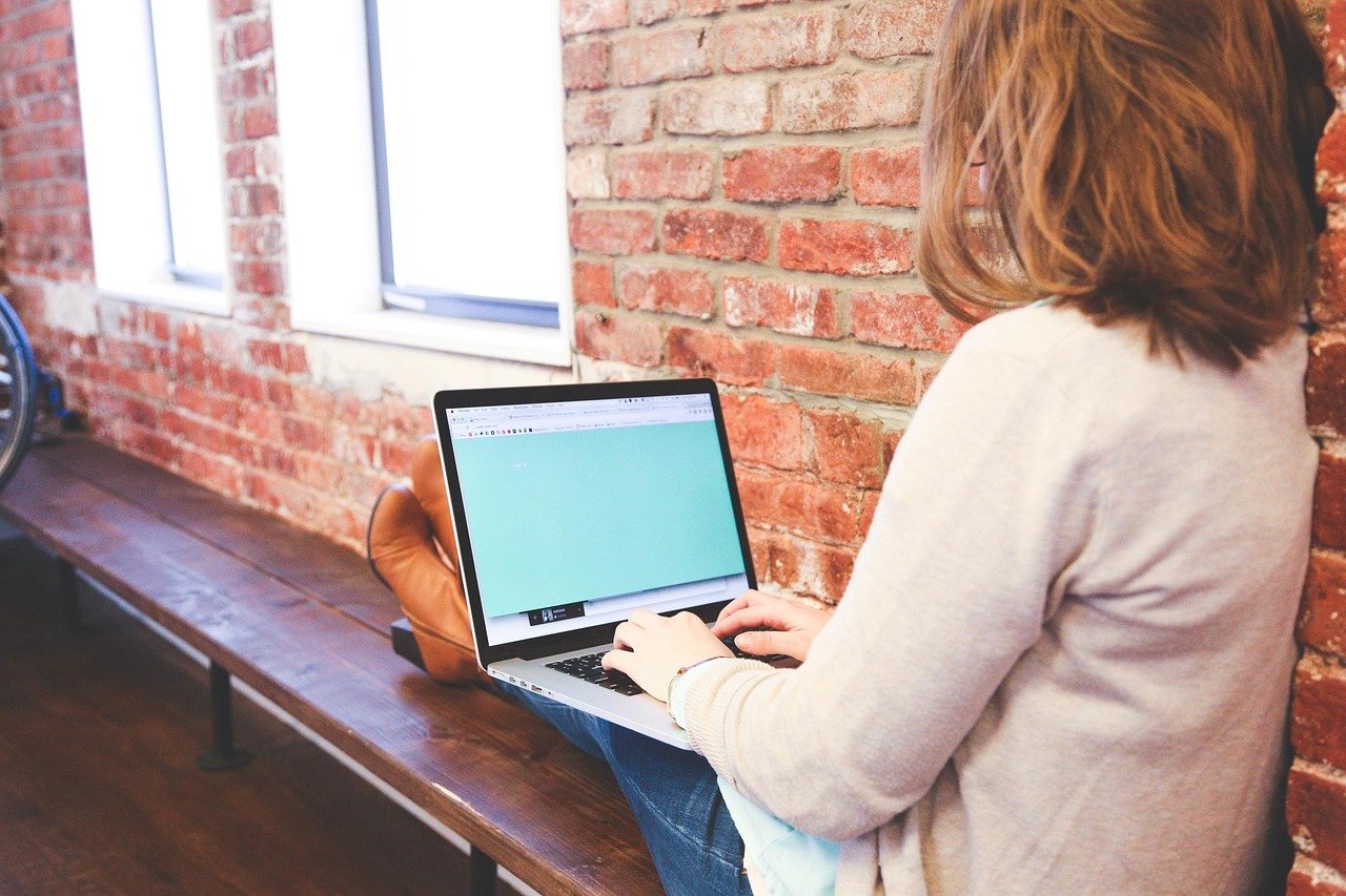 Mulher digitando no teclado, explorando como capturar e-mails com anúncios.