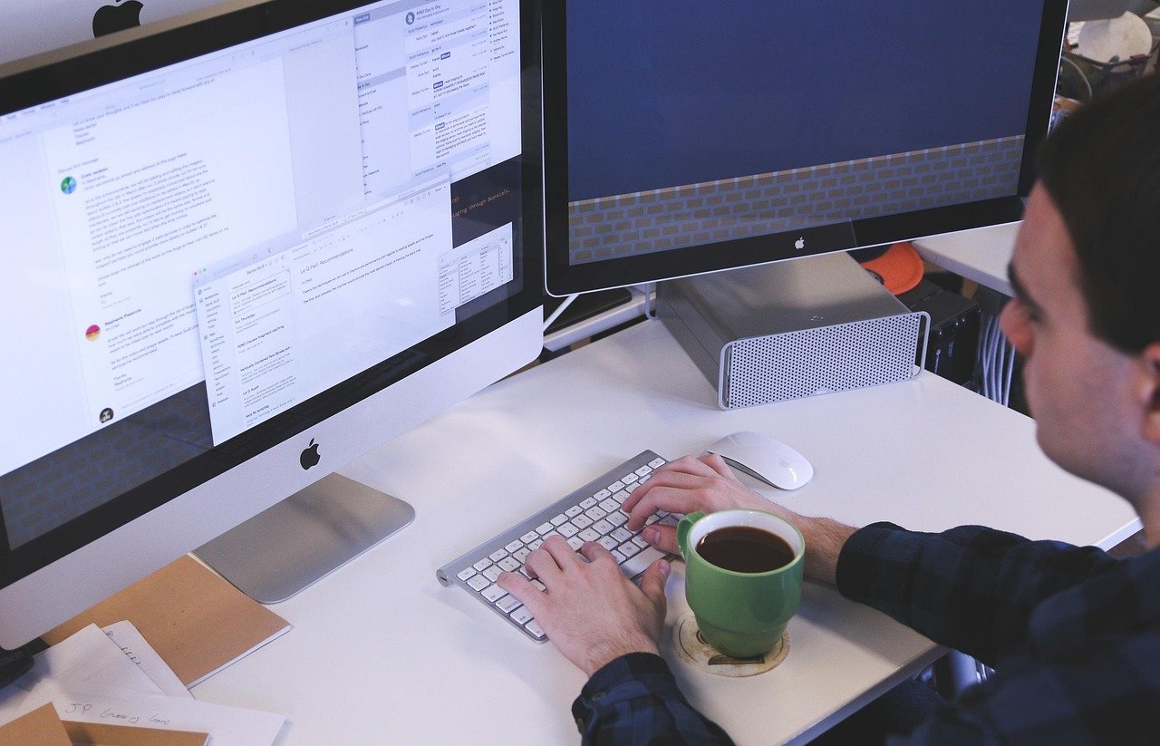 Homem digitando no computador representando como capturar e-mails com anúncios.